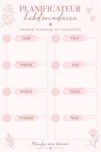 Un planner rose ouvert avec des notes et des stylos sur une table en bois