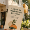 Une femme souriante lisant un livre de développement personnel dans un café, entourée d'un cadre chaleureux.