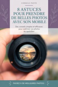 Une femme souriante prenant des photos avec son smartphone dans un parc ensoleillé.